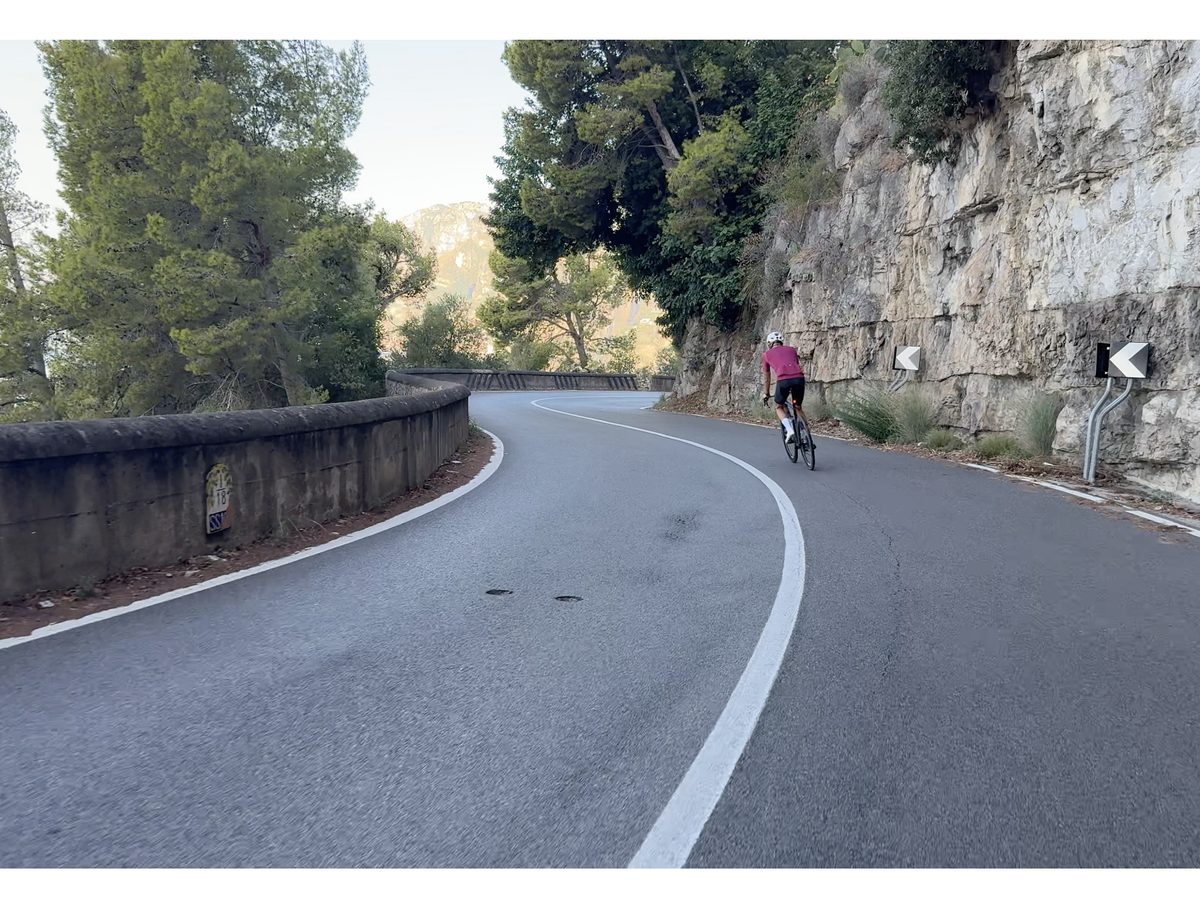 Un ciclista su bici da strada in discesa su una strada di montagna sopra la Costiera Amalfitana
