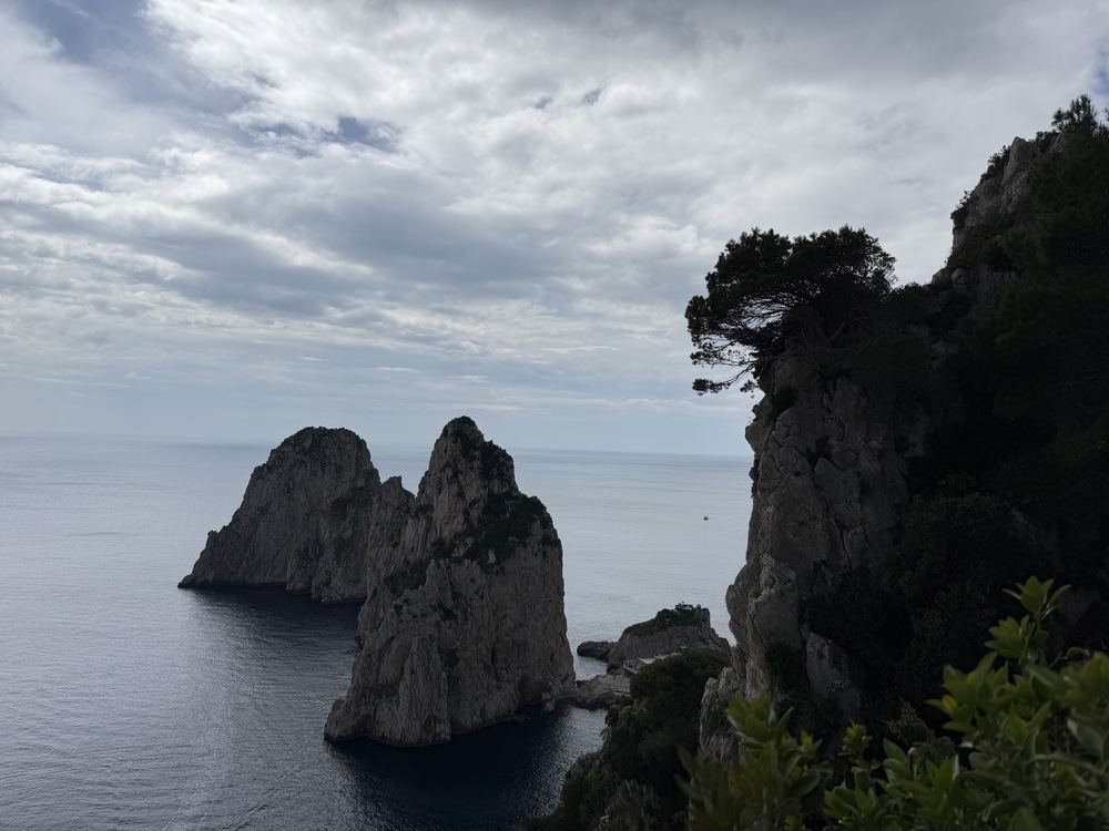 View of the Faraglioni sea stacks from a cliff path on Capri